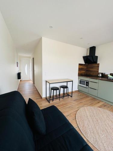 un salon avec un canapé et une table dans l'établissement Logement avec terrasse, à Mimizan