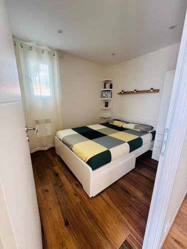 - une chambre avec un lit et une couette noire et jaune dans l'établissement Logement avec terrasse, à Mimizan