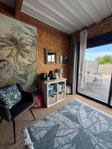 un salon avec une chaise et une grande fenêtre dans l'établissement Chambre de la mer blanche, à Bénodet