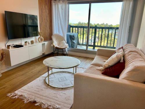 un soggiorno con un divano e una grande finestra di Appartement front de mer Cabourg a Cabourg