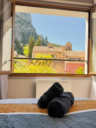 - une serviette posée sur un lit devant une fenêtre dans l'établissement Coeur de Moustiers Gorges du Verdon, à Moustiers-Sainte-Marie