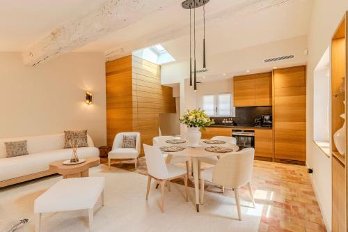 a dining room and living room with a table and chairs at Le Yaca Saint-Tropez in Saint-Tropez