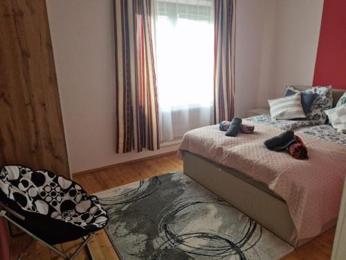 a bedroom with a bed and a chair and a window at Villa Donaublick in Kleinpöchlarn