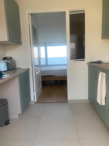 une cuisine avec une porte menant à une chambre dans l'établissement TY KERVIGORN les pieds dans l'eau, à Saint-Pabu