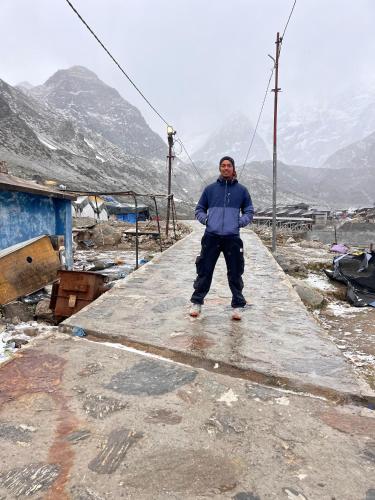 a man standing on a walkway in the mountains at Kedarnath Camps by Annu in Kedārnāth