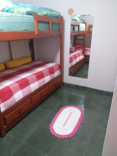 a room with two bunk beds and a mirror at Vanderli - Deli in São Vicente