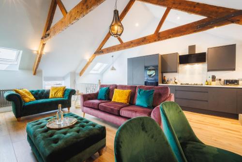 a living room with couches and chairs and a kitchen at A stunning 3 bed Apartment in Fishguard
