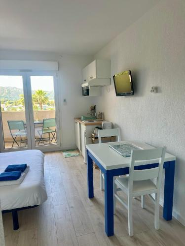 - un salon avec une table et une cuisine avec vue dans l'établissement Joli studio avec balcon vue mer à Saint-Florent, à La Celle-sous-Gouzon