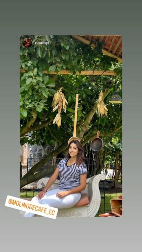 a woman sitting on a bench in a garden at Molino de Café Cabañas Lodge in Chinchín Loma