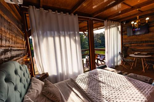 a bedroom with a bed in front of a window at Chale do Mirante in Blumenau