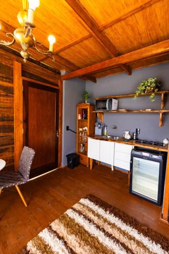 a living room with a tv and a table and a couch at Chale do Mirante in Blumenau