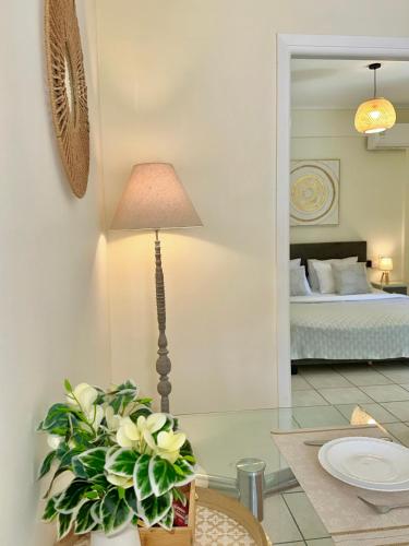 a table with a lamp and a vase with white flowers at Sophilia Garden escape in Patra