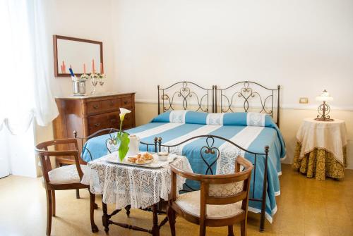 1 dormitorio con 1 cama con mesa y sillas en Villa La Meridiana - Caroli Hotels en Leuca