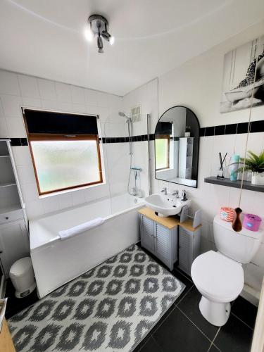 a bathroom with a tub and a toilet and a sink at Family-Friendly Spacious 3BR, Near Uni & Town in Worcester