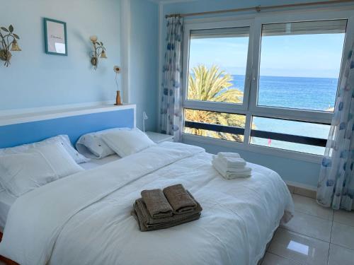 ein Schlafzimmer mit einem großen Bett mit Handtüchern darauf in der Unterkunft Gemütliches Apartment mit tollem Meerblick in Arguineguín