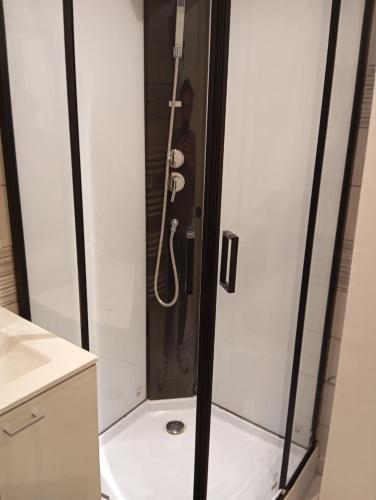 une douche dans une salle de bain avec une personne debout dedans dans l'établissement Saturne, à Saint-Quentin