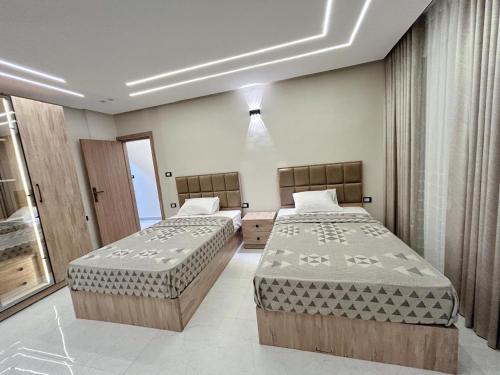 a bedroom with two beds and a window at Comfy 3 Bedrooms Apartment in Cairo Sheraton Airport in Cairo