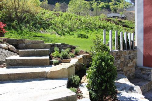 a garden with stone steps and plants in a yard at MyVerzasca Resort Casa Rossa in Brione