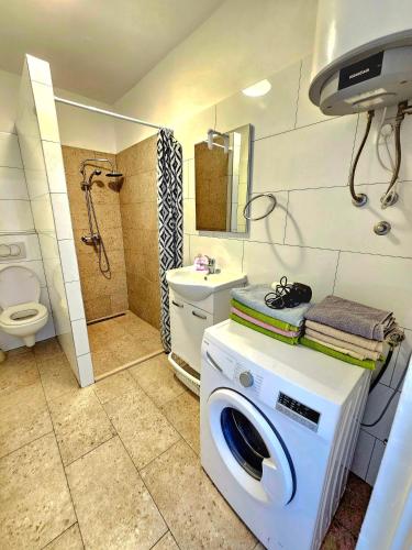 a washing machine in a bathroom with a toilet at Bepo in Zadar