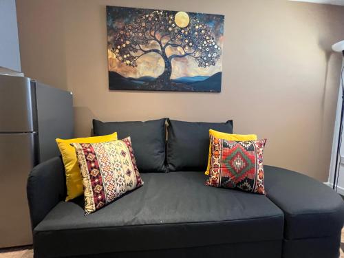 a couch in a living room with a painting on the wall at Glastonbury Harmony, Split-Level 1 bedroom Apartment in Glastonbury