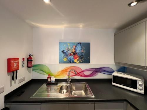 a kitchen with a sink and a microwave at Glastonbury Harmony, Split-Level 1 bedroom Apartment in Glastonbury