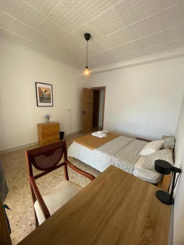a room with two beds and a table and a chair at Asthet Sevilla in Mairena del Aljarafe