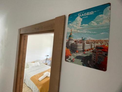 a picture hanging on a wall next to a bed at Asthet Sevilla in Mairena del Aljarafe