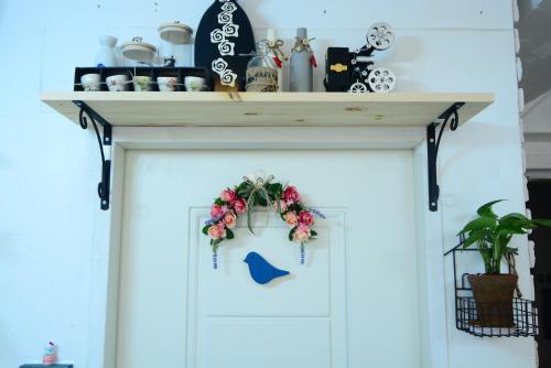 a shelf over a white door with flowers on it at Residence Unicorn in Seoul