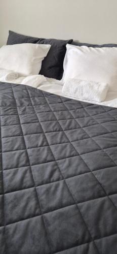 a bed with black sheets and white pillows at Spacious 2BR Apartment near Olavinlinna Castle in Savonlinna