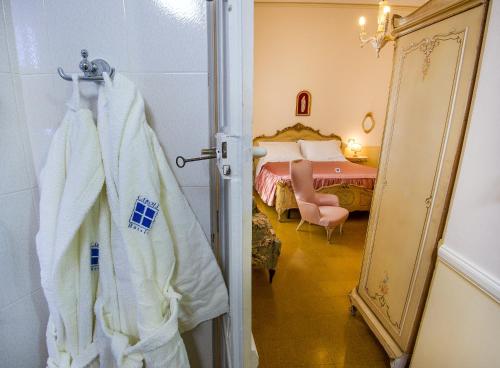 a bathroom with a robe hanging on a door at Villa La Meridiana - Caroli Hotels in Leuca