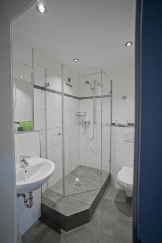 a bathroom with a shower and a sink and a toilet at Hotel-Restaurant Zum Hirschhaus Inklusiv Chiemgaukarte in Ruhpolding