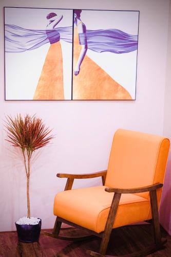 a room with a chair and a picture of a woman on the beach at SuGar Homestay in Hanoi
