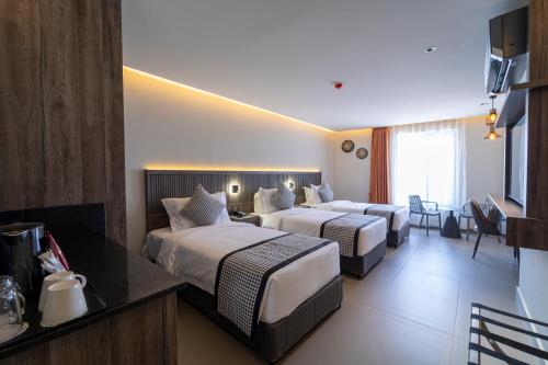 a hotel room with two beds and a television at Hill Top Hotel in Aqaba