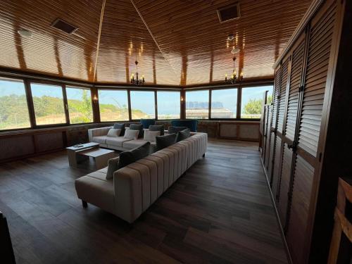 a large room with couches and tables and windows at Olinda Hotel & Spa in Şile