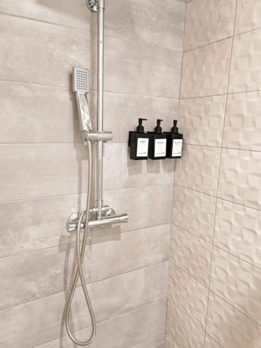 une douche avec pommeau de douche dans une salle de bain dans l'établissement Bulle tropicale jungle, à Clermont-Ferrand