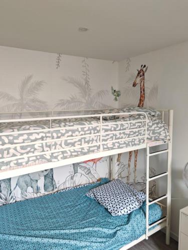 une chambre avec un lit superposé avec un papier peint girafe dans l'établissement Bulle tropicale jungle, à Clermont-Ferrand
