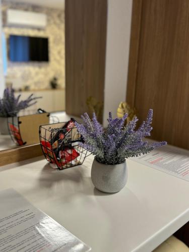 a vase with purple flowers sitting on a table at Apartments HAN 2 Sarajevo in Sarajevo