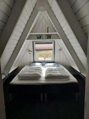 un letto nel centro di una stanza con finestra di Holiday home golf house in beautiful Himmerland Farsø a Farsø