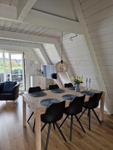 una sala da pranzo con tavolo e sedie in legno di Holiday home golf house in beautiful Himmerland Farsø a Farsø