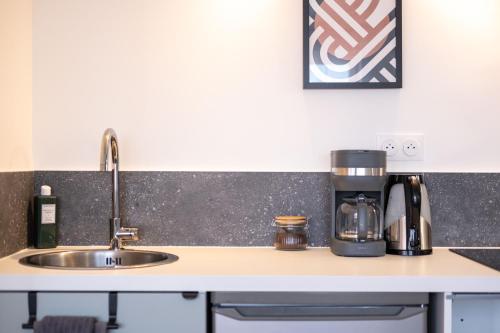 - un comptoir de cuisine avec évier et cafetière dans l'établissement Chez Mona L Hyper centre Lens 1 ch, à Lens