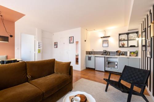 un salon avec un canapé et une cuisine dans l'établissement Chez Mona L Hyper centre Lens 1 ch, à Lens