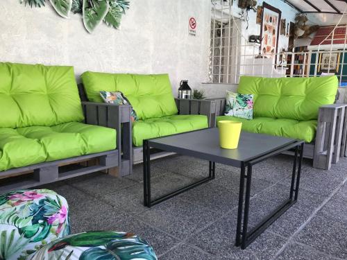 a patio with green couches and a coffee table at Lady Hamilton B&B in Feletto