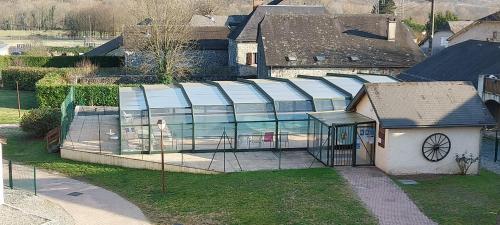a house with a glass roof in a yard at Les Epicuriens in Bielle