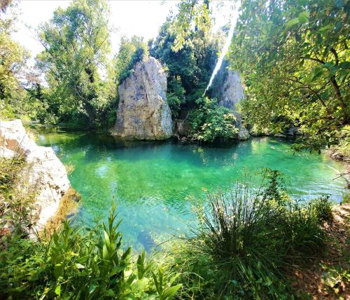 a pool of water with a waterfall in a forest at Renovated and air-conditioned 2-bedroom apartment with terrace in Saint-Paul-de-Fenouillet