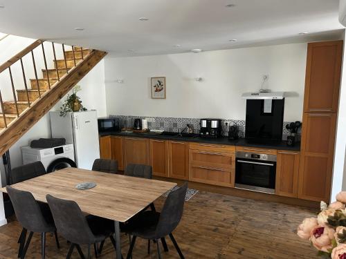 une cuisine avec une table en bois et une salle à manger dans l'établissement Petite maison de village, à Beaulieu-sur-Dordogne