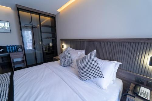 a bedroom with a bed with white sheets and pillows at Hill Top Hotel in Aqaba