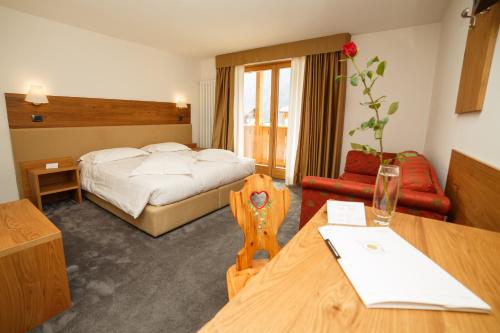 a hotel room with a bed and a table at Olympic regina hotel in Pinzolo