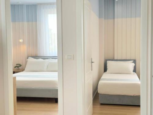 a bedroom with two beds and a window at PROMO Elegant Apartments NEW - Colorful by the sea in Durrës