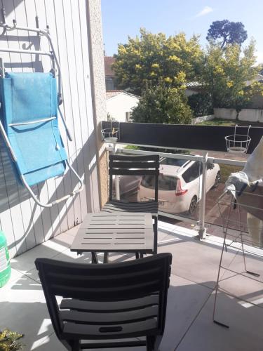 une chaise, une table et une voiture sur un balcon dans l'établissement Studio ronce les bains, à La Tremblade