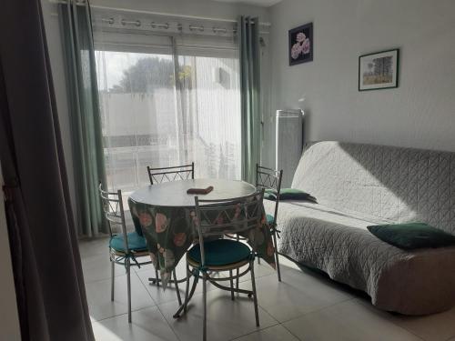 - une chambre avec une table et des chaises à côté d'un lit dans l'établissement Studio ronce les bains, à La Tremblade